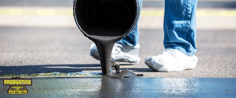 Worker pouring black asphalt sealant from a container onto a paved surface