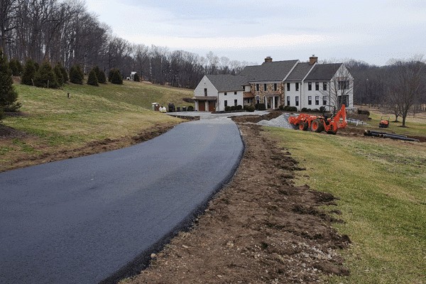 New asphalt driveway paving by Productive Asphalt Paving in front of a large house.