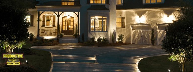 House with double garage doors and an illuminated driveway at night