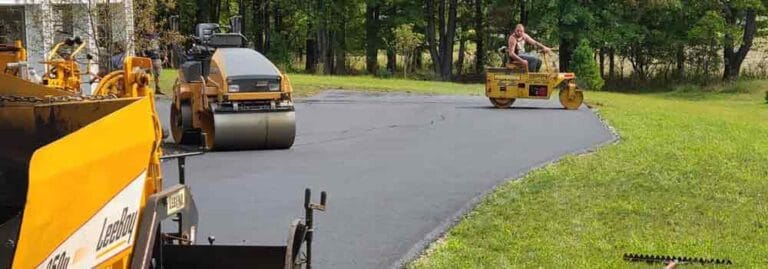 Asphalt paving process with heavy machinery for durable, high-quality driveway or road installation.